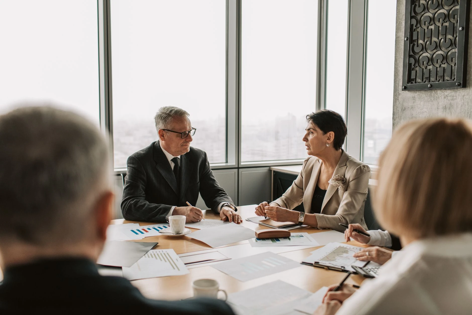 Roda de discussão entre executivos em mesa de reunião